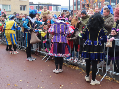 912287 Afbeelding van enkele Pieten, de assistenten van Sinterklaas, die kruidnoten ronddelen na zijn aankomst per boot ...